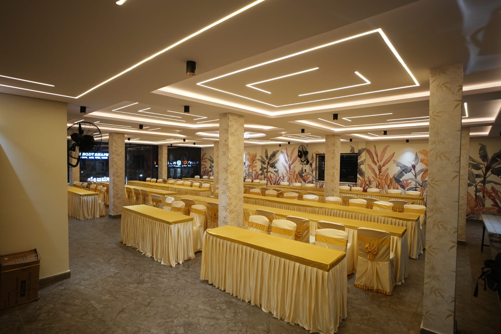 Dining hall seating with tropical murals and designer ceiling lighting