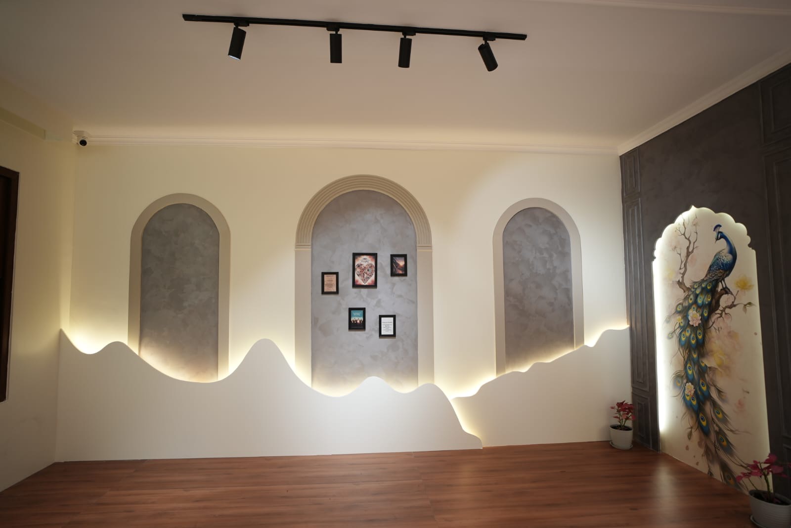 Foyer with arched wall niches and illuminated peacock artwork