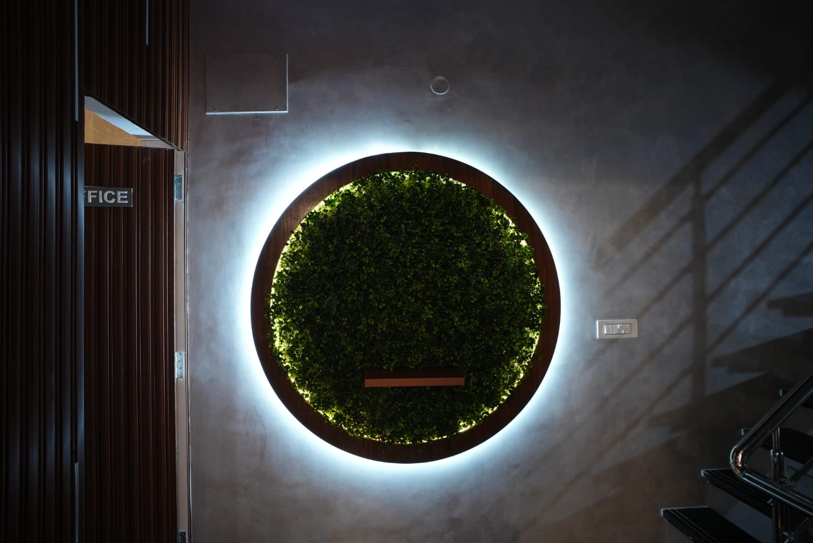 Entrance lobby with backlit circular green wall near the office